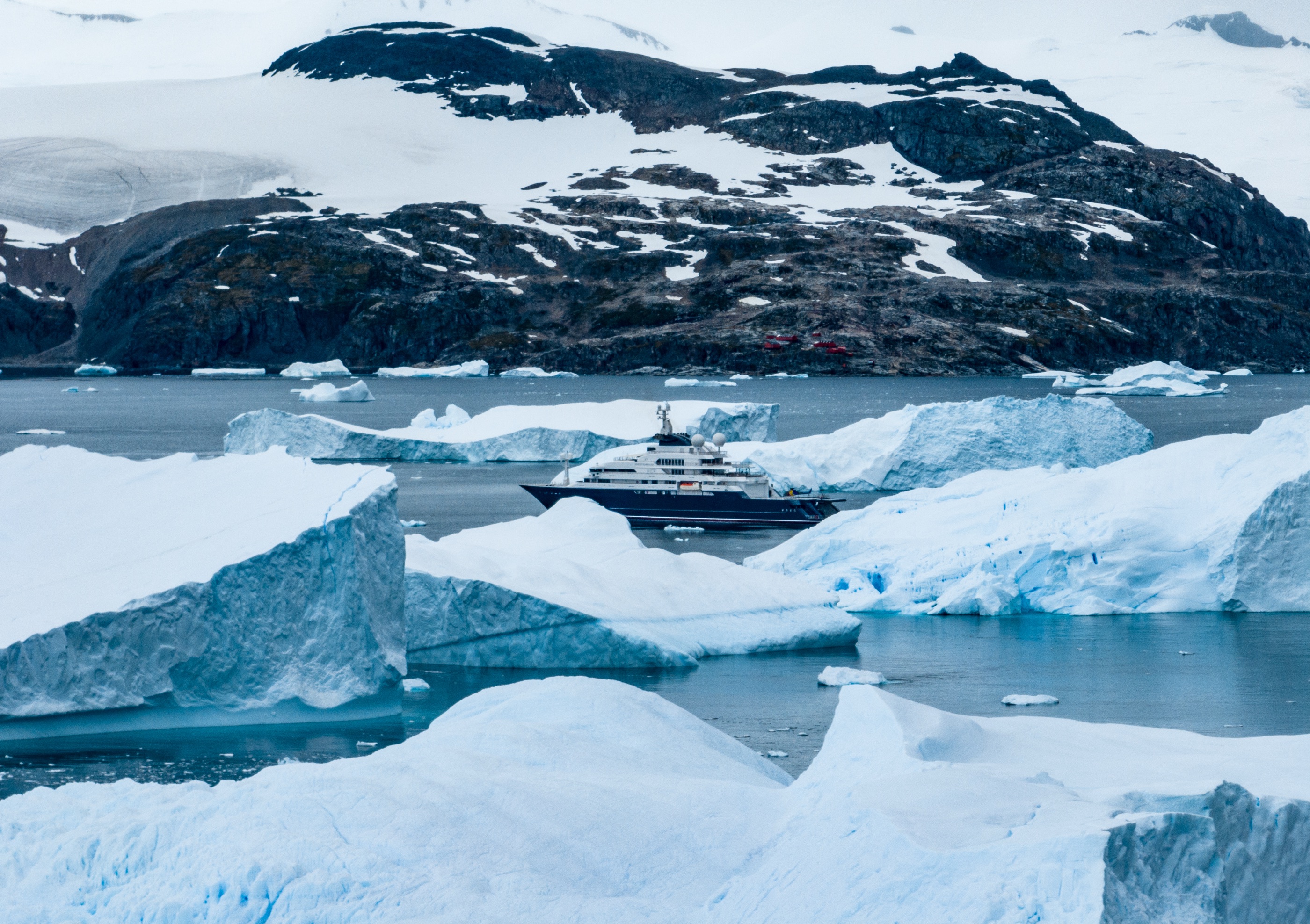 Explorer yacht framed between blue icebergs